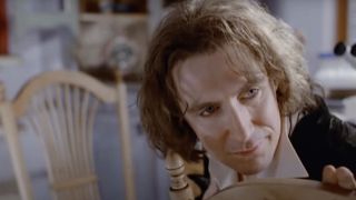 Paul McGann's Eighth Doctor sitting in chair and looking over at Grace