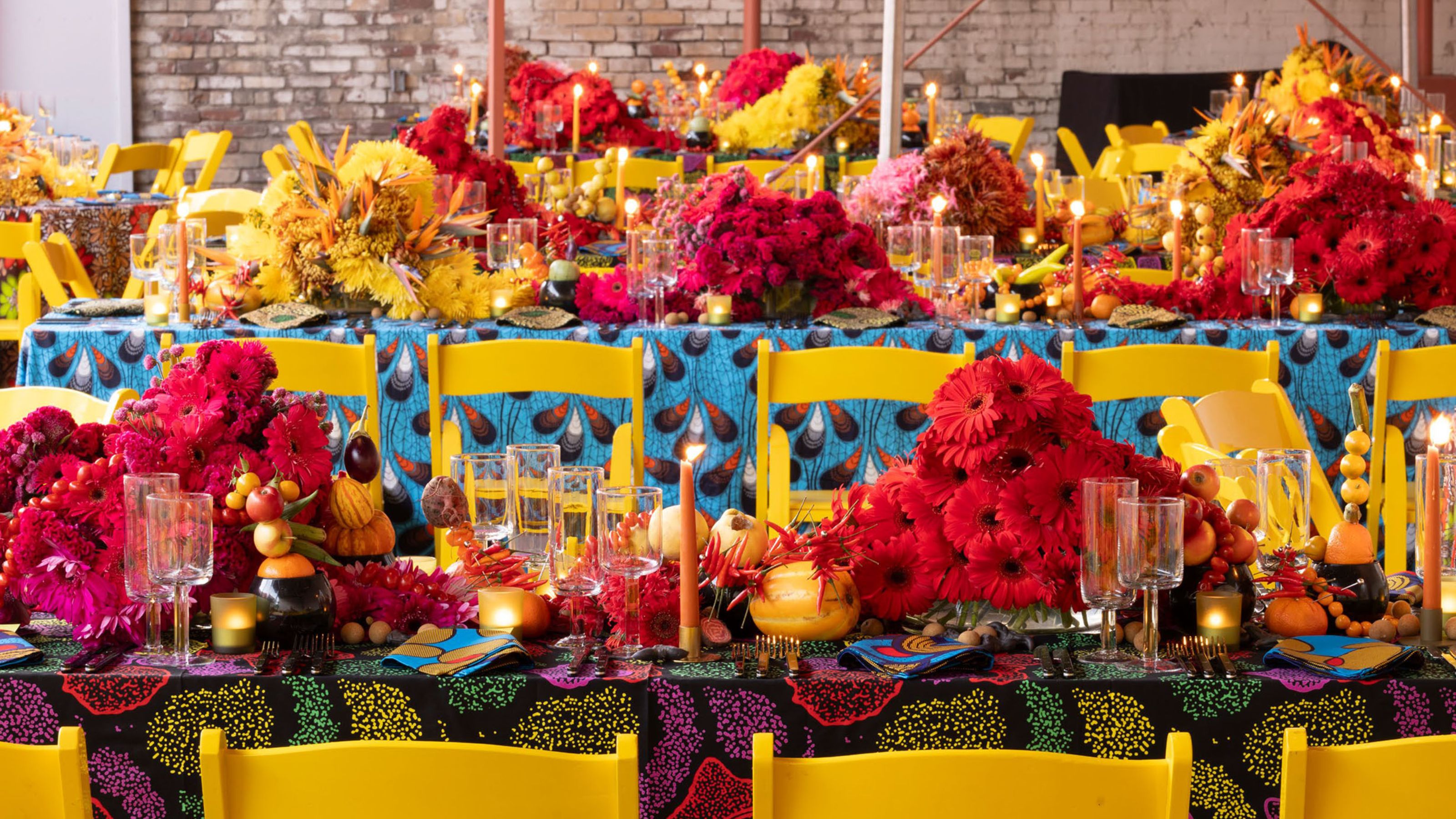 Colorful table layout with red flowers and yellow chairs