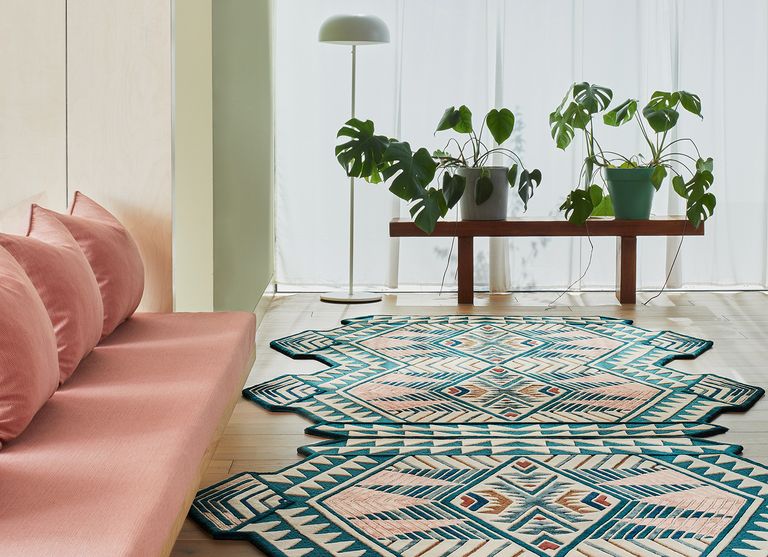 geometric rug in a living room with a pink sofa