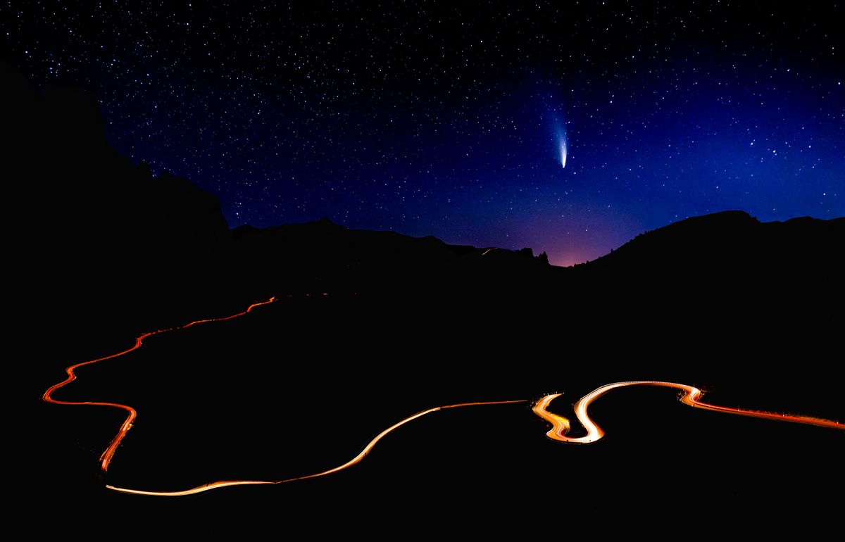 Comet C/2022 E3 (ZTF) over the road in the mountains at nigh