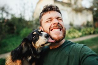 man taking selfie with dog