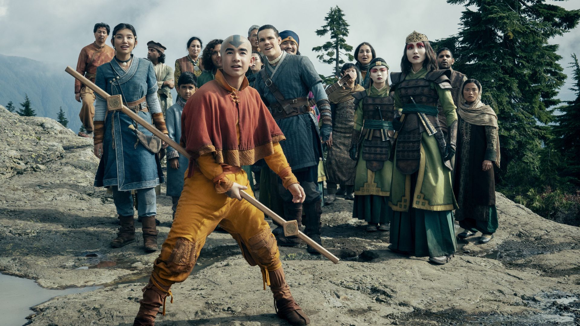 Aang protege a un grupo de personas sobre una roca