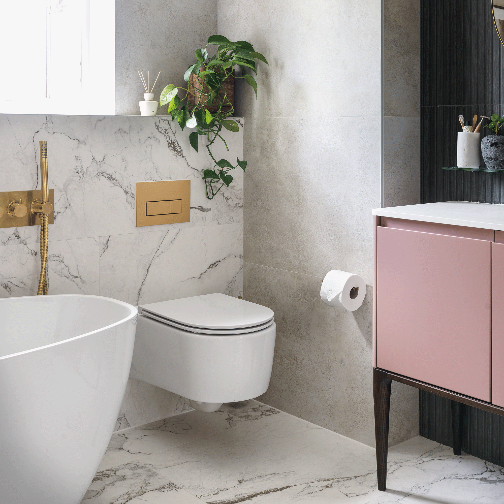 a bathroom with a modern pink vanity unit with sink beside a wall-hung loo and bath tub