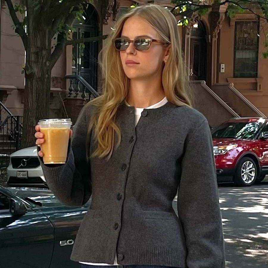 Danish style influencer and creative Clara Dyrhauge holding a coffee wearing a chic outfit with a gray fitted cardigan and dark jeans—the winter 2025 2026 dark-wash denim trend