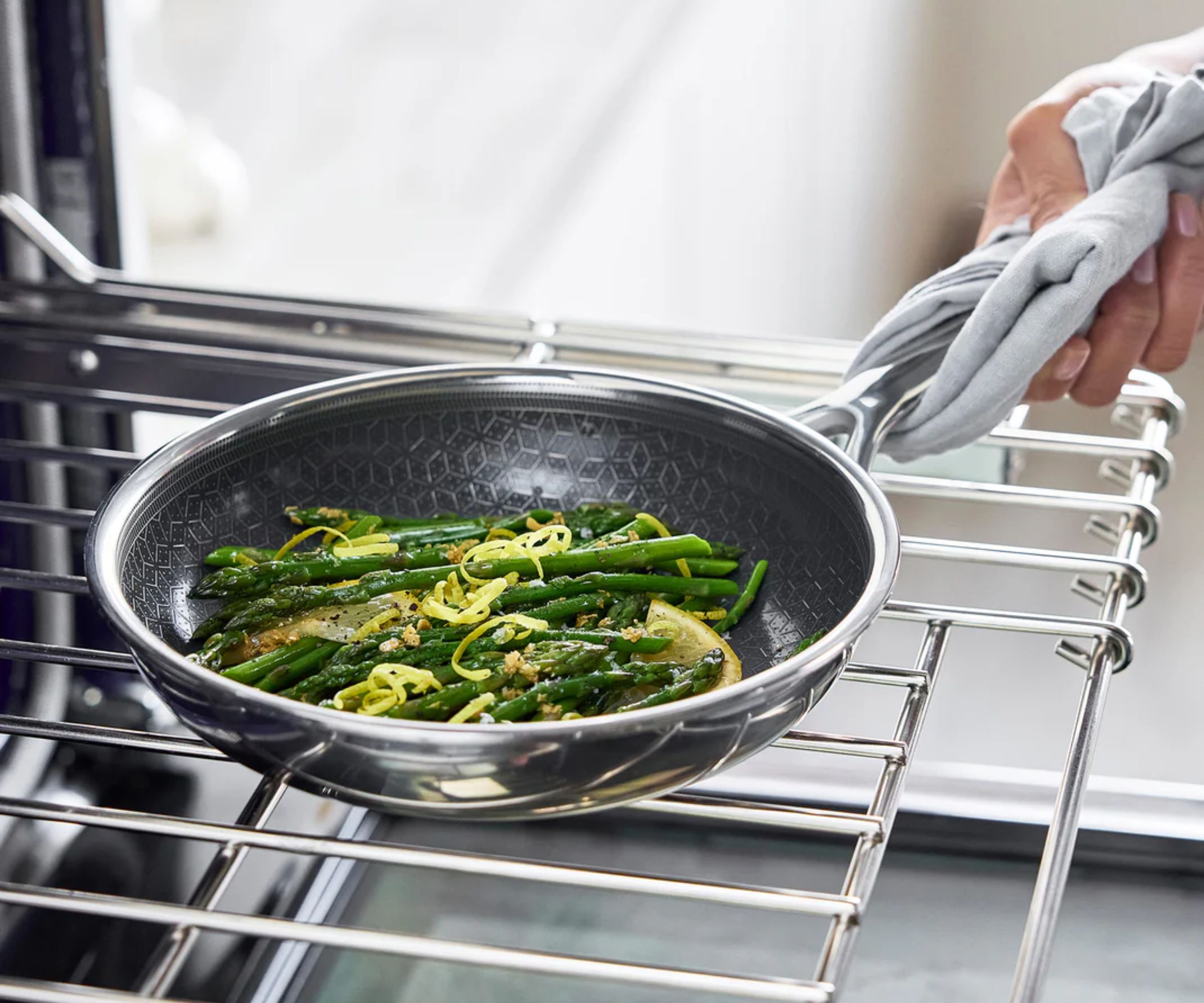 GreenPan Spectra Thermobod Frying Pan filled with asparagus being lifted from an oven rack.