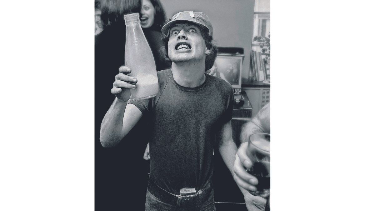 Angus Young of AC/DC holding a milk bottle