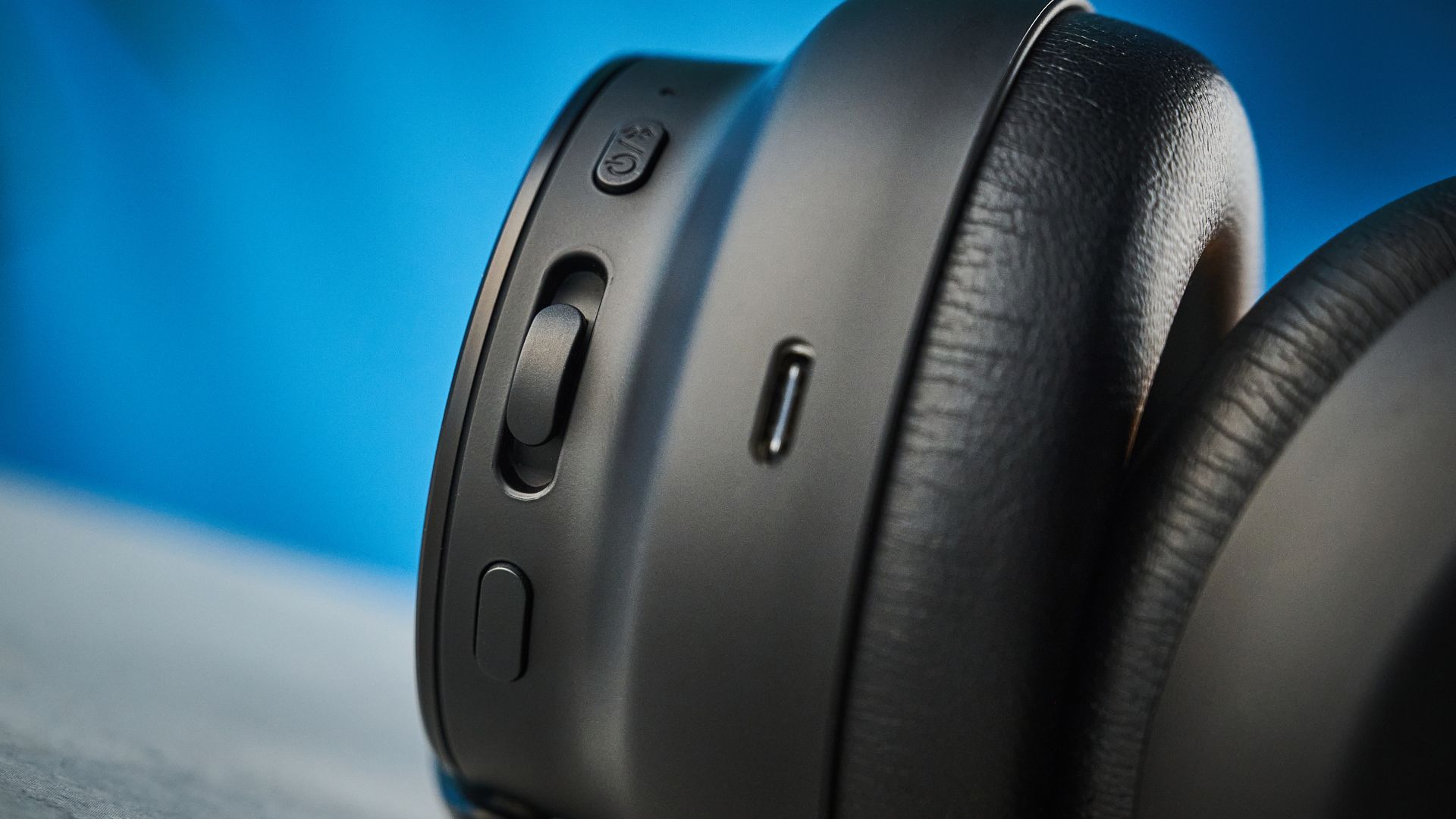 the technics eah-a1000 headphones with a gold technics logo photographed against a blue background
