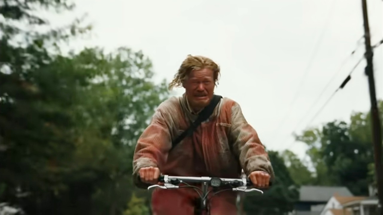 Jesse Plemons crying while riding a bike in Bugonia.