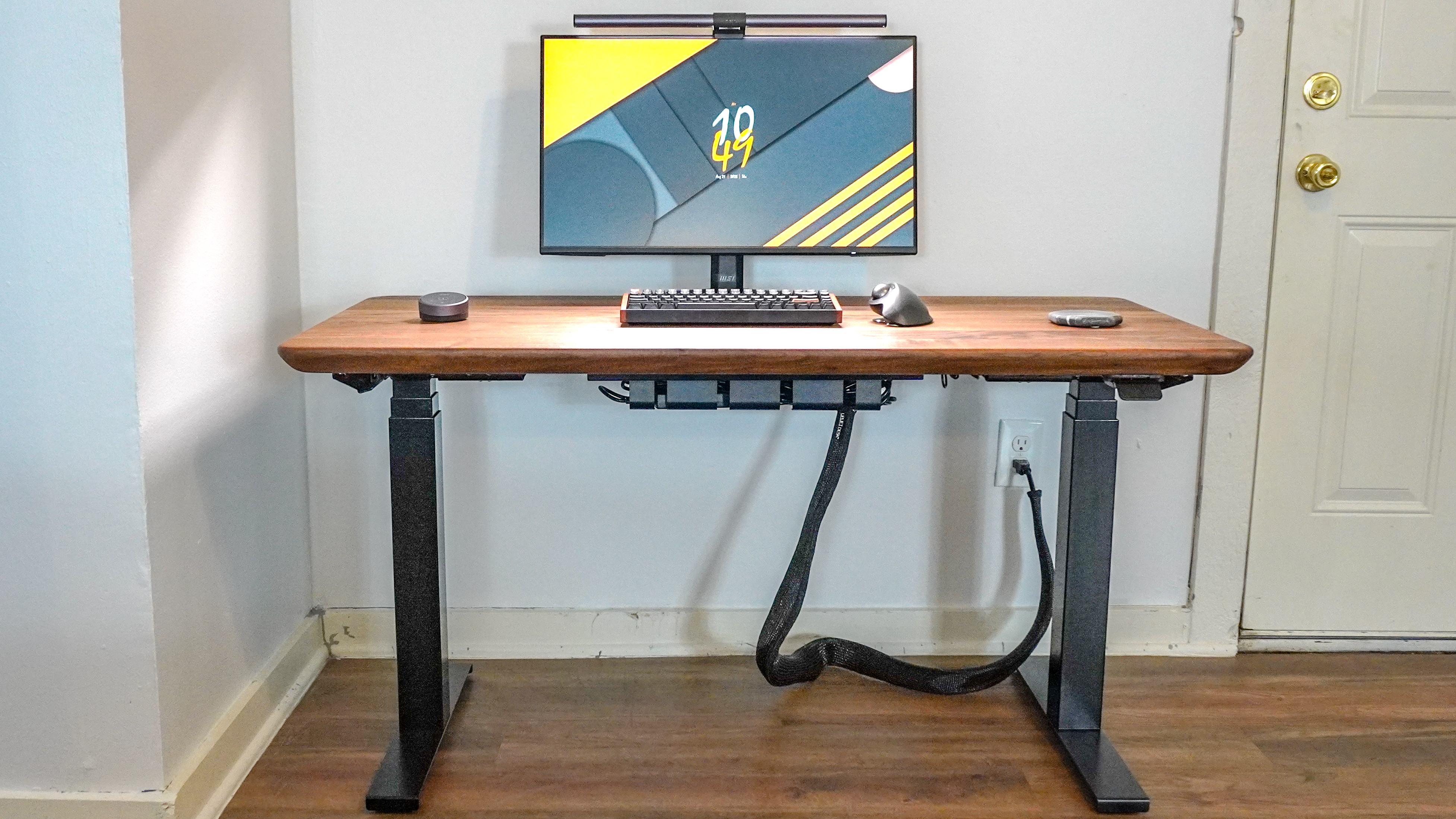 The Oakywood Standing Desk Pro with a single monitor and a keyboard and mouse on top of it