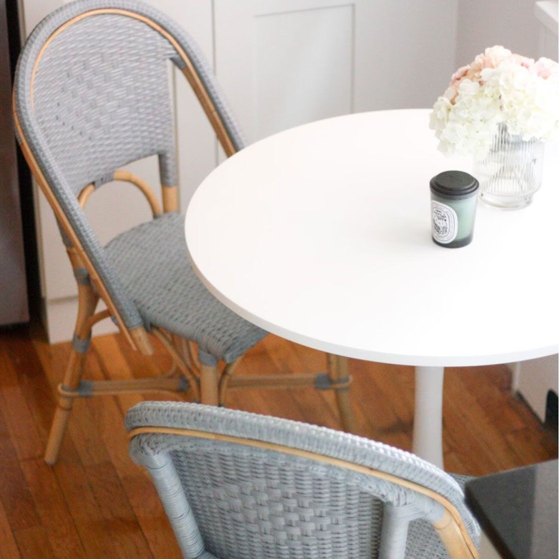 Meja bundar putih dengan lilin dan hydrangea dengan kursi biru pastel