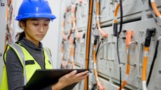 A technician inspecting a battery energy storage system (BESS).