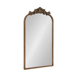 A gold mirror with ornate detailing