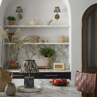 Kitchen with marble worktop and open shelving with lamp