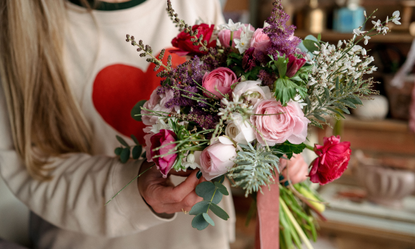 Hands holding a pink, green and purple hand-tied bouquet