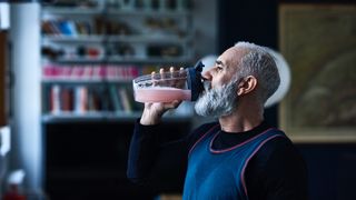 Man wearing running top drinking a smoothie