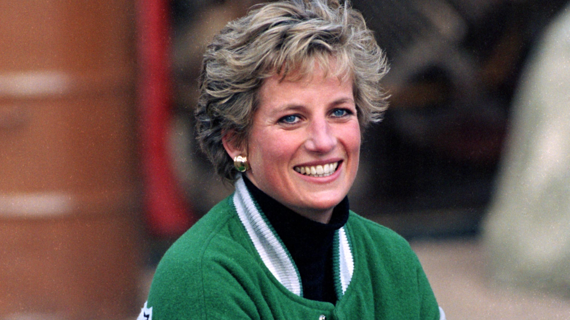 Princess Diana wearing a green Eagles jacket and smiling