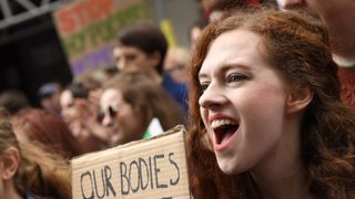 Woman protesting with "Our bodies, our choice" sign
