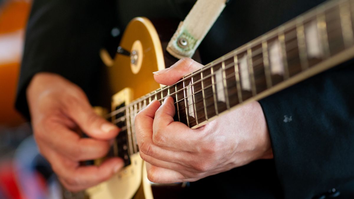 Closeup of hands playing guitar