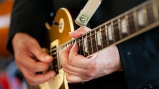 Closeup of hands playing guitar