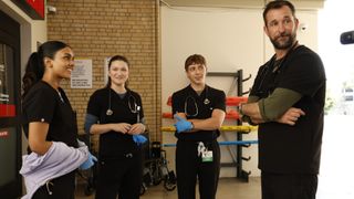 Javadi, Santos, Whitaker, and Robby standing around in the ambulance bay on The Pitt.
