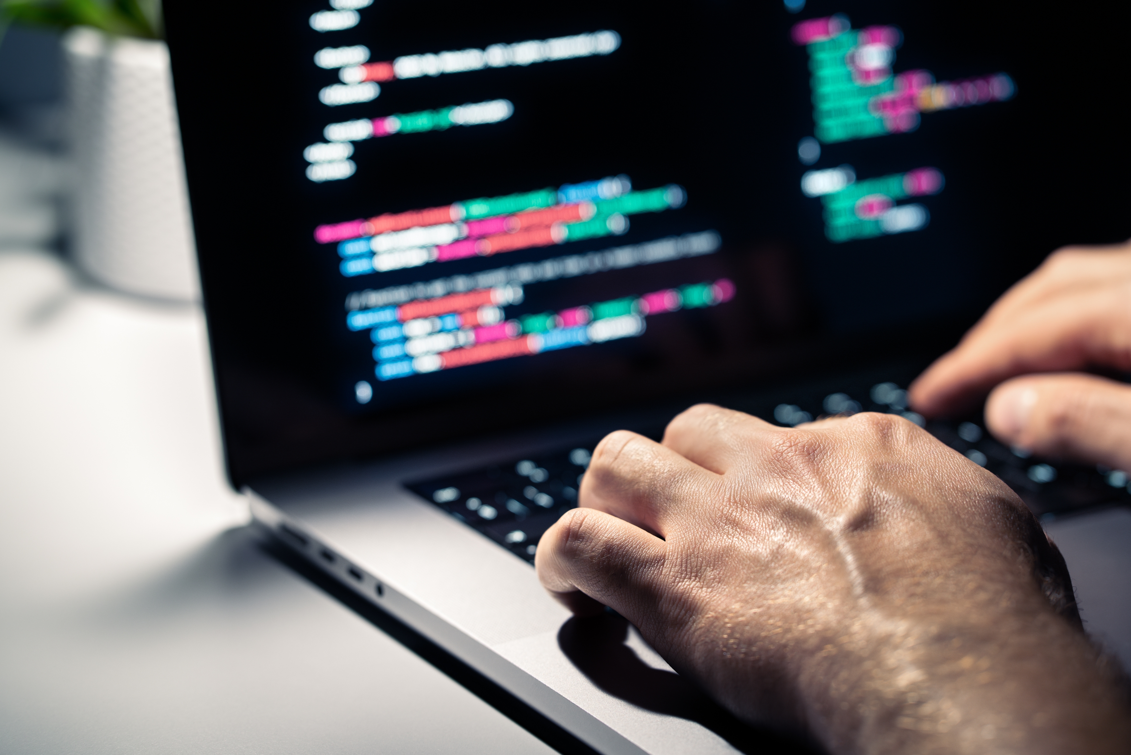 Hacker with malware code in computer screen. Cybersecurity, privacy or cyber attack. Programmer or fraud criminal writing virus software. Online firewall and privacy crime. Web data engineer