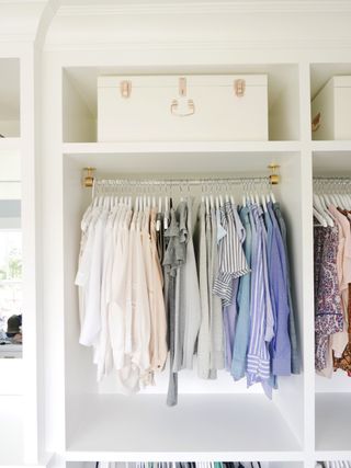clothes hanging neatly in a white closet