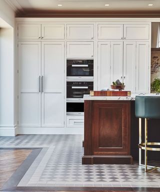 white shaker kitchen by naked kitchens with dark wood island