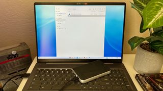 A Lenovo Chromebook with a hard drive plugged in and sitting on top of the keyboard.