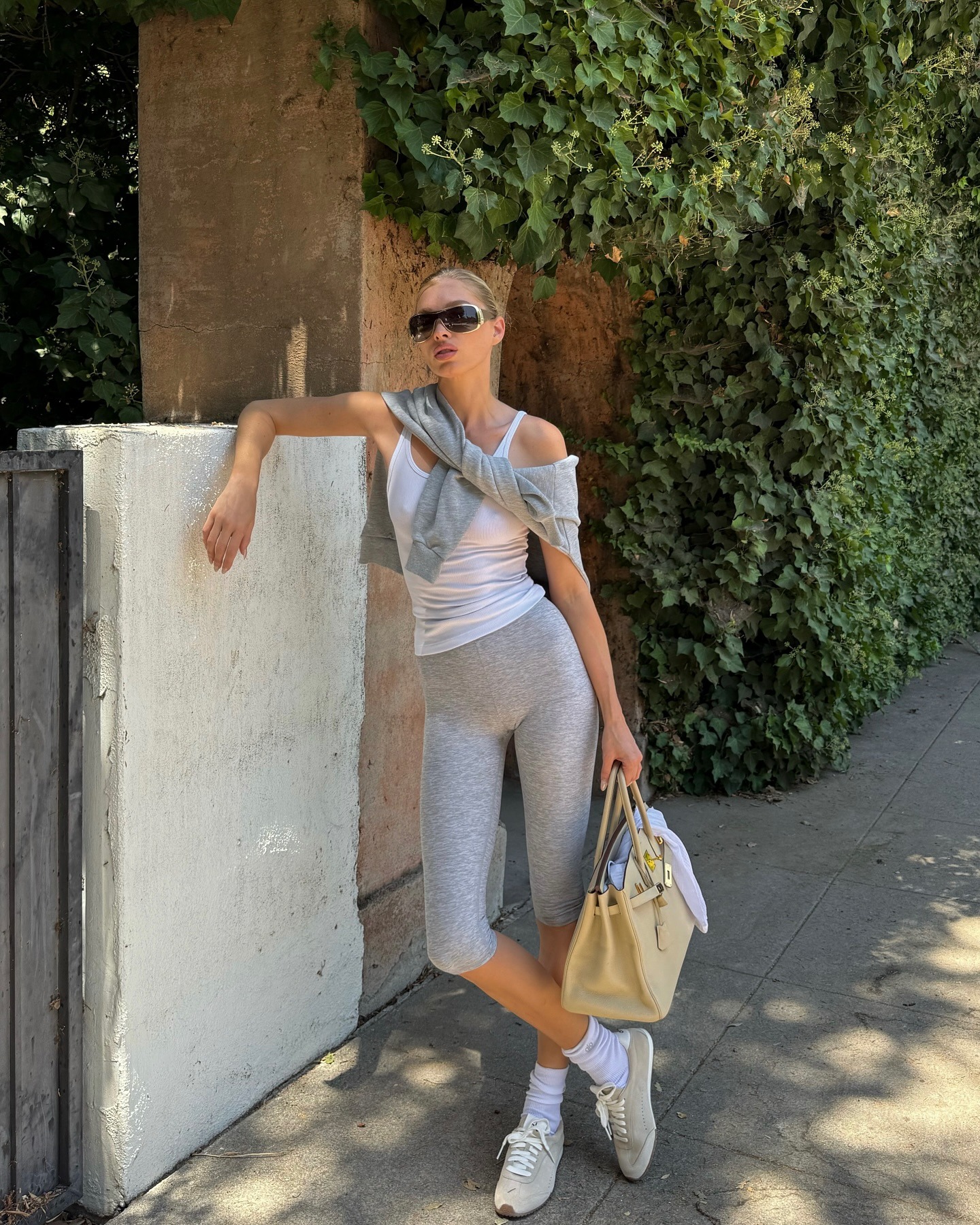 Elsa Hosk wearing a white tank top with Alo capri leggings and Sunset sneakers