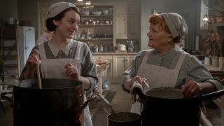 Sophie McShera and Lesley Nicol talk as they work in the kitchen in Downton Abbey: A New Era.
