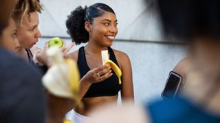 What to eat before a workout: Image shows group of women eating fruit in workout gear