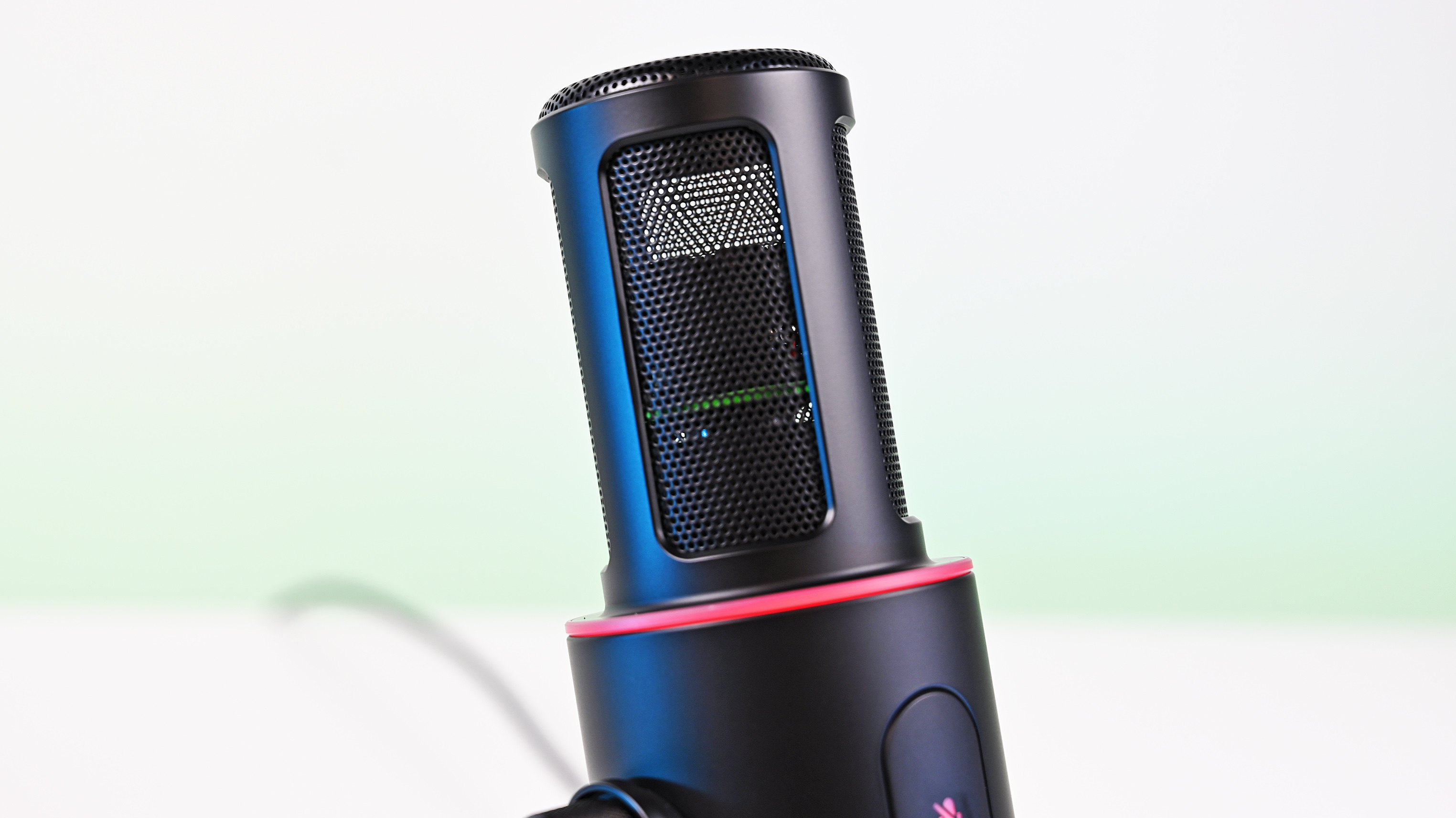 Close-up of the Razer Seiren V3 Pro with its foam pop filter removed, revealing the metal mesh grille, internal dynamic capsule, and red LED ring.