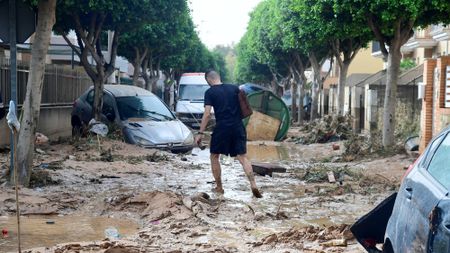 A man walks in a street covered in mud in a flooded area in Picanya, near Valencia, in October 2024