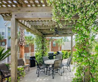 Chairs and grills under a pergola