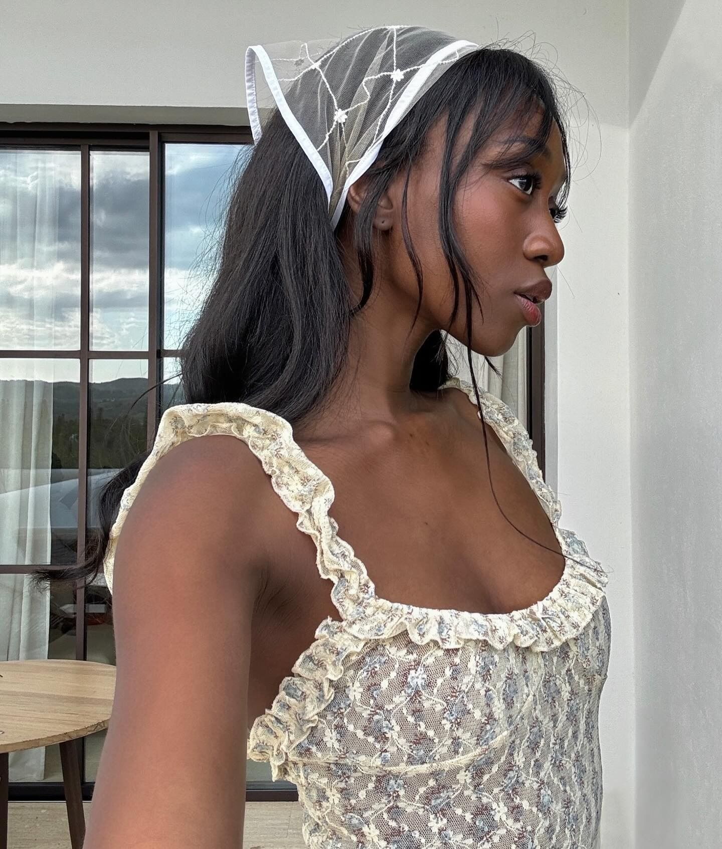 French woman wearing a lace headscarf.