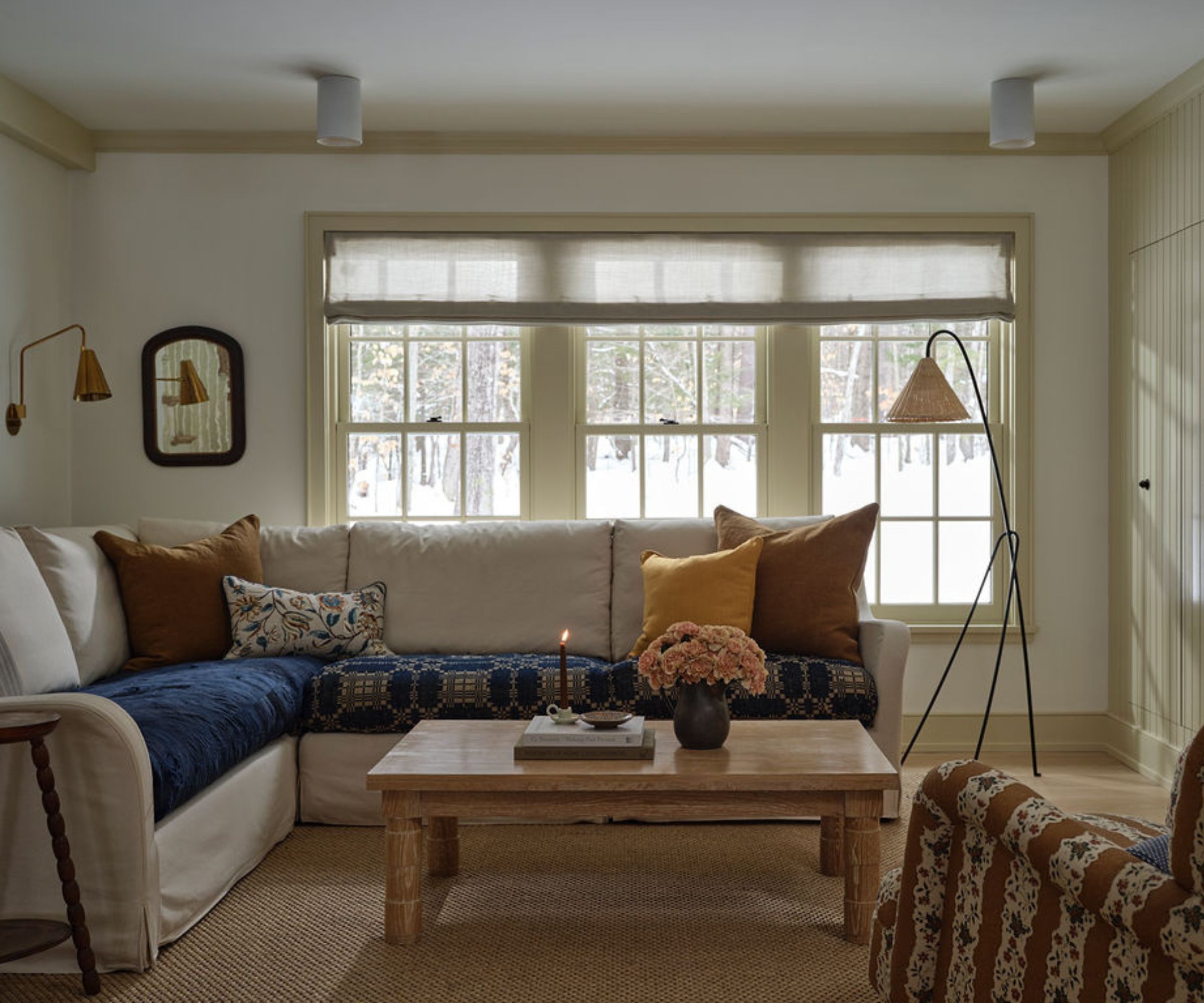 A neutral living area with an L-shaped couch and patterned armchairs