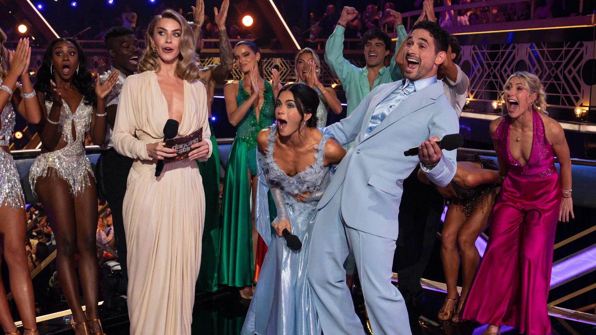 Julianne Hough looking shocked while Jenna Dewan and Alan Bersten celebrate.