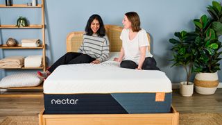 Two Toms' Guide mattress testers sat on the Nectar Ultra Hybrid mattress smiling and laughing at each other