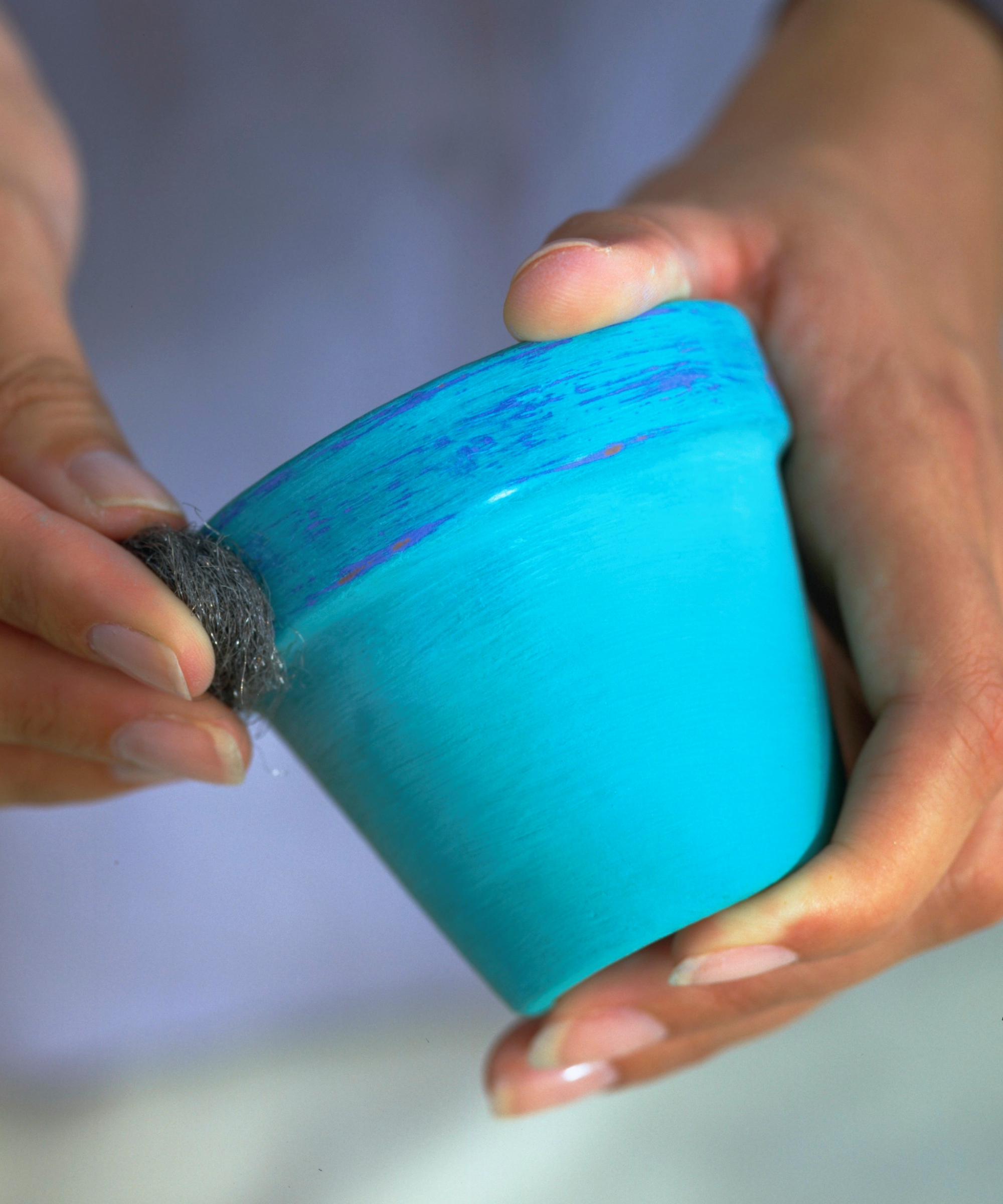 painted plant pot being aged with wire wool