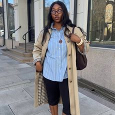 @nnennaechem wears capri pants with a blue shirt and a trench coat