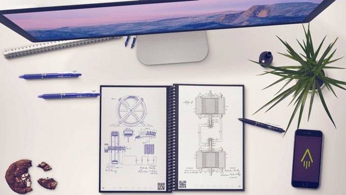 The Everlast notebook with technical drawings sits at a desk with pens, a Mac and a phone nearby