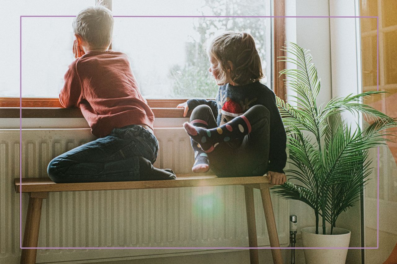 two kids sat at window looking bored