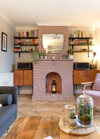 Small living room with pink brick fireplace and alcoves filled with mid-century modern furniture