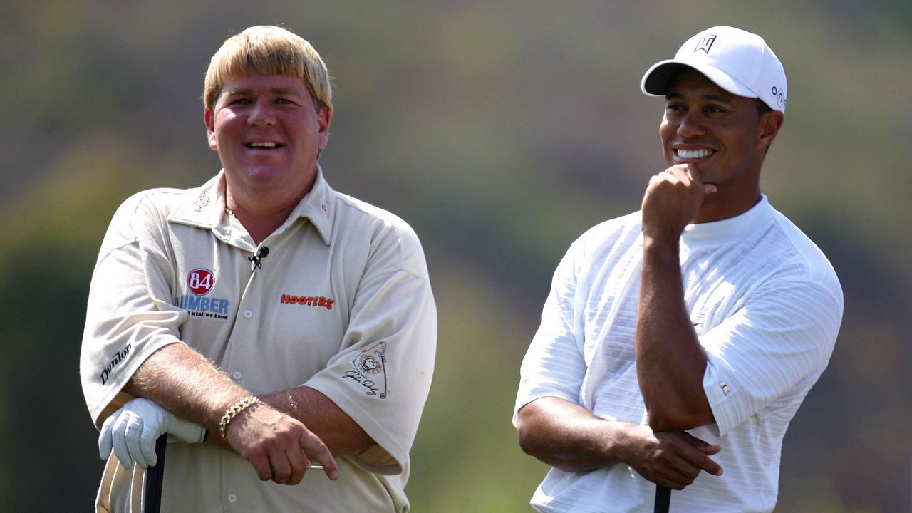 John Daly and Tiger Woods pictured smiling and sharing a joke.