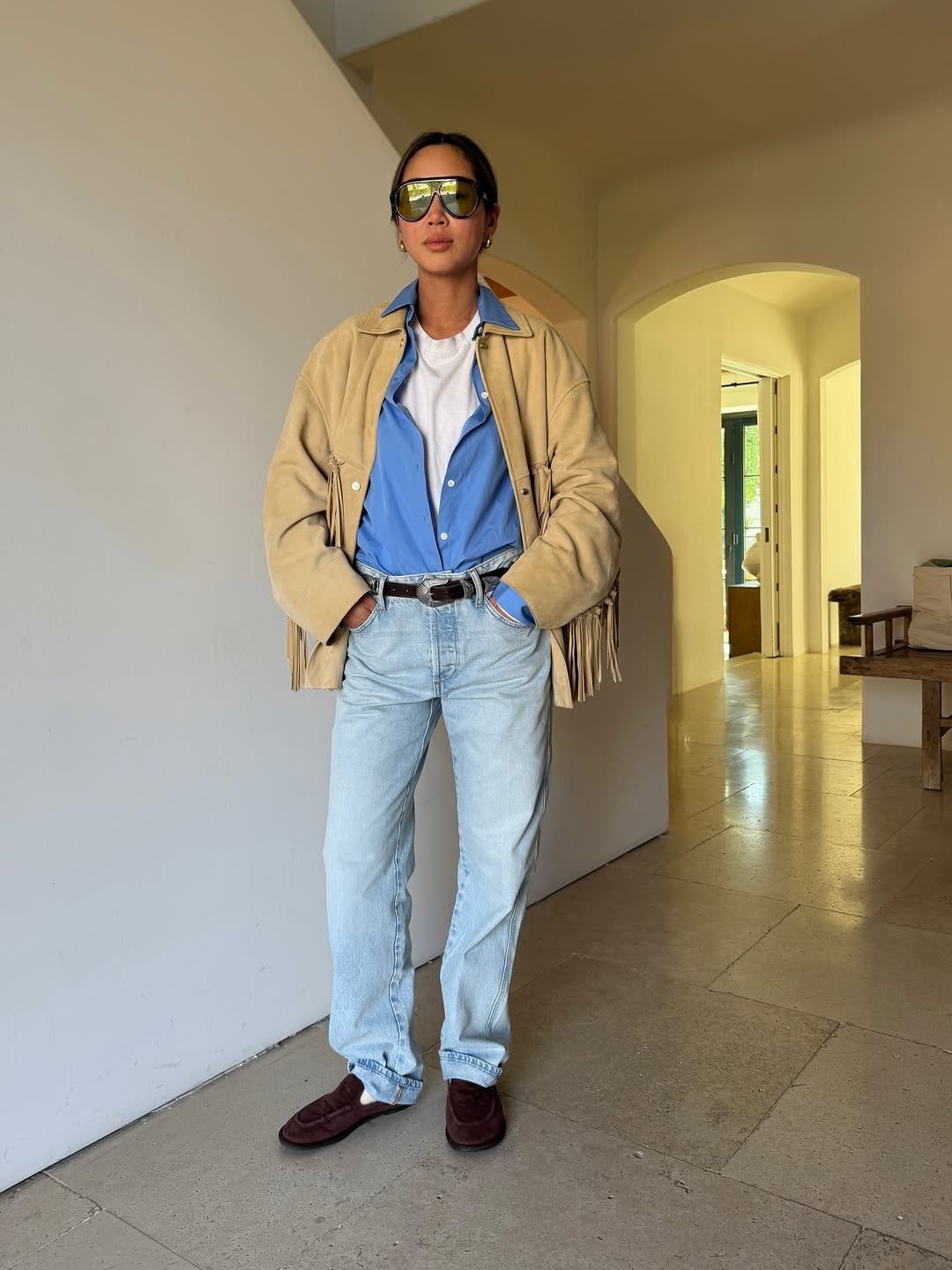 A woman wearing interesting layers, one of the biggest 2026 spring to summer transitional trends.