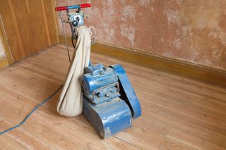 a floor sander being used for sanding floorboards