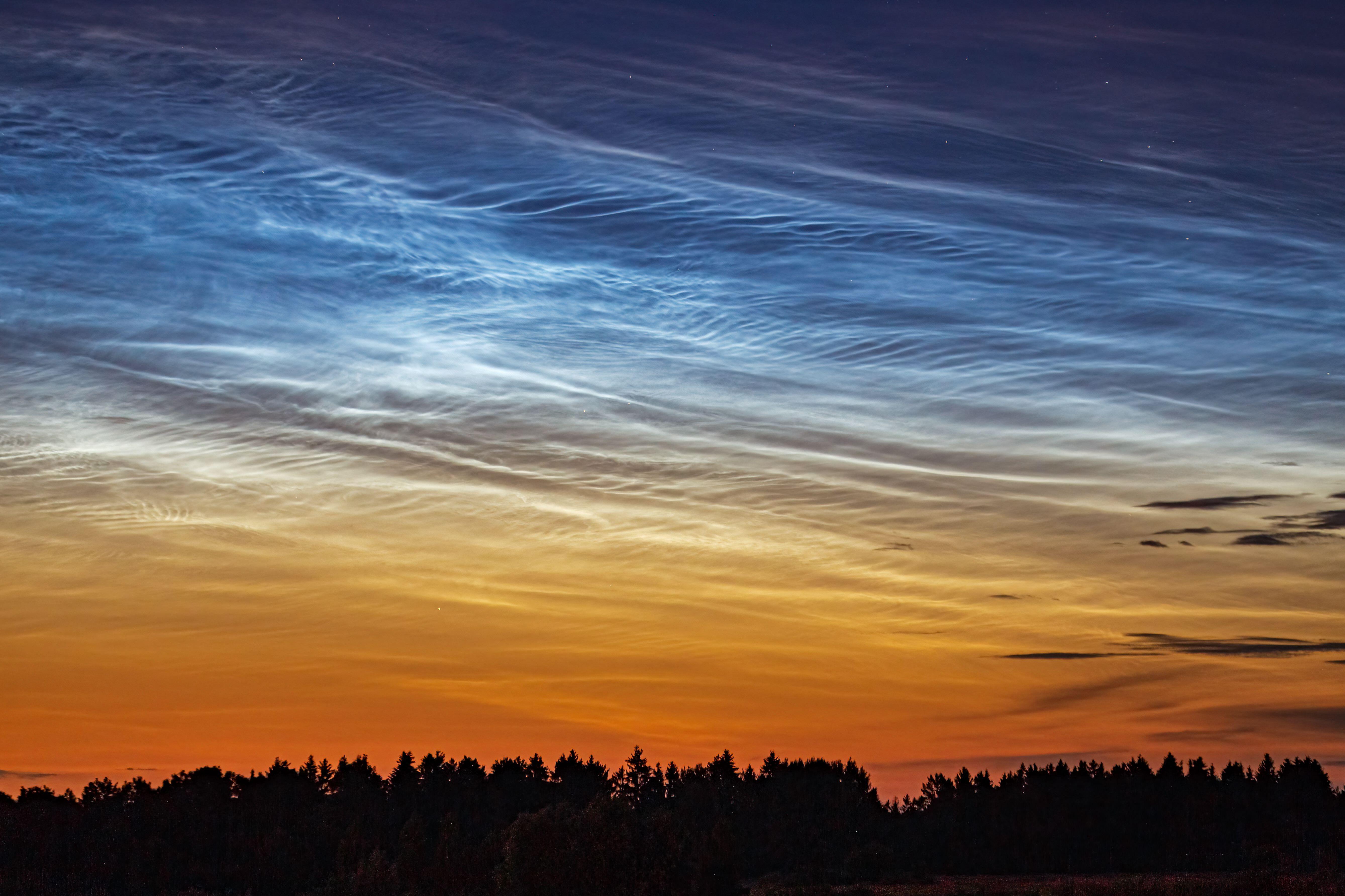 Night shining - Noctilucent clouds at night. They look thin and very high up, almost like trails in space
