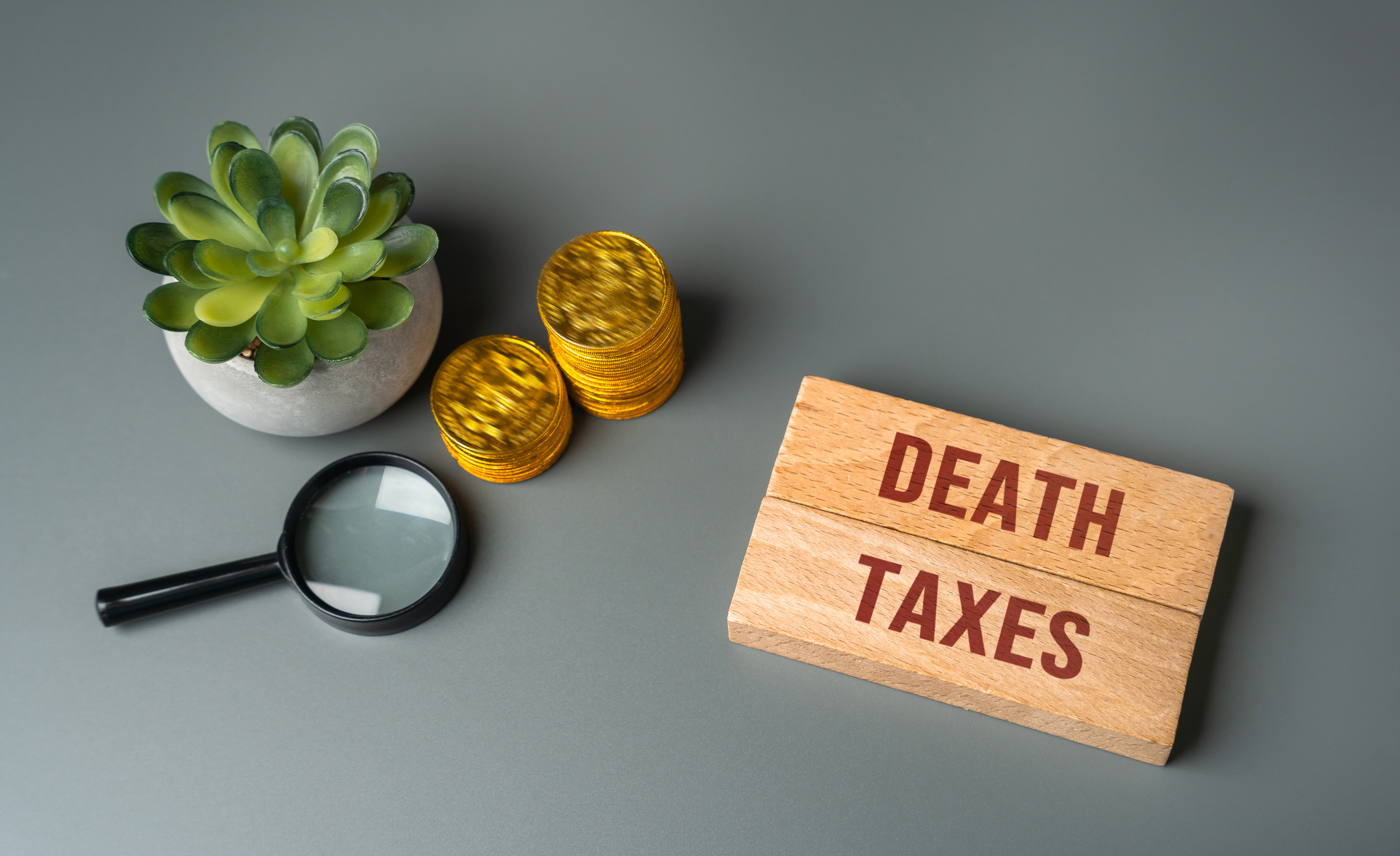 Wooden blocks with death and taxes inscribed on them. Death is certain and so are taxes on the money or property you leave behind. 