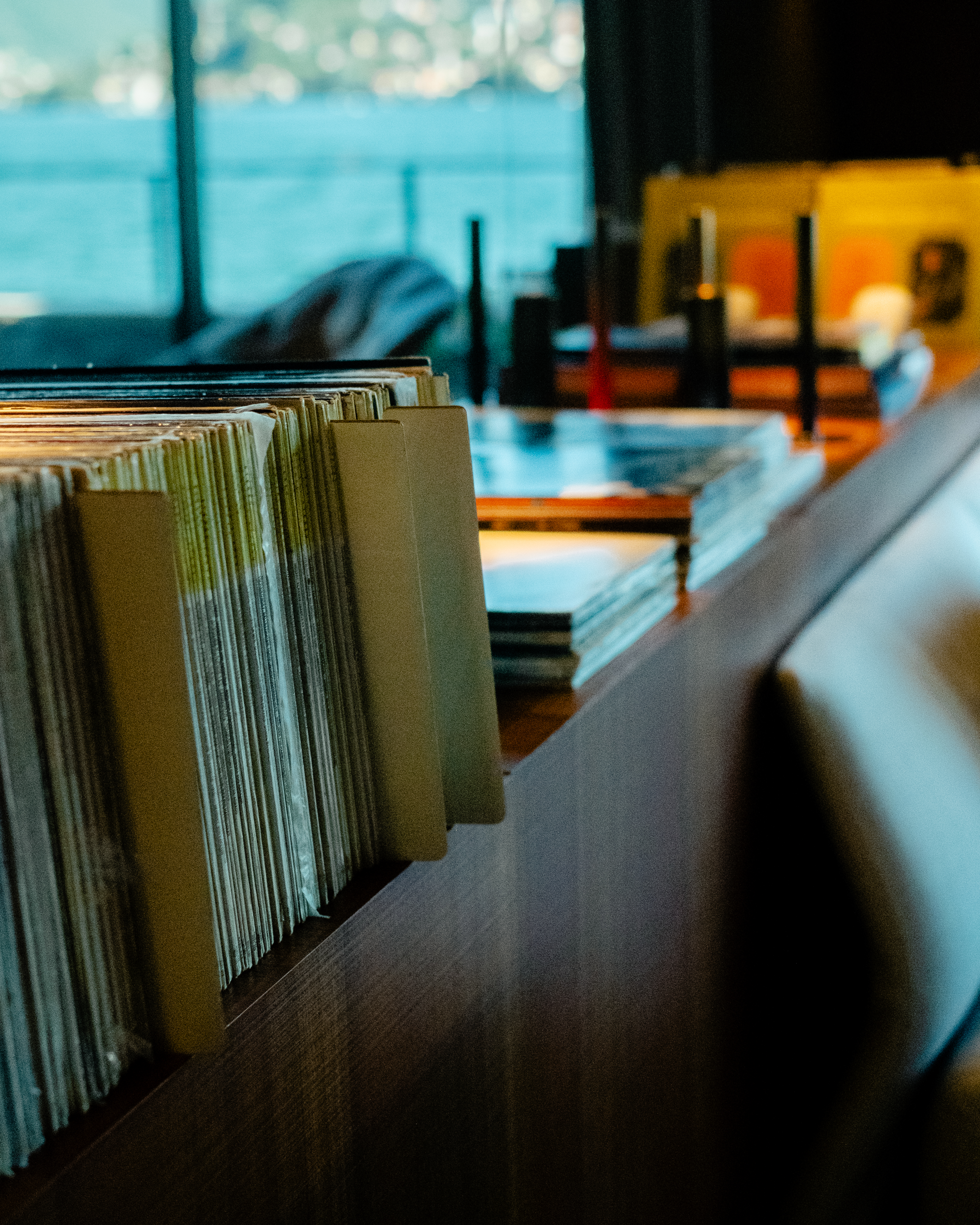 A high-fidelity suite fitted with retro-inspired amplifiers, speakers, a turntable, and a sprawling record collection features a mid-century-cool vibe through wood-clad surfaces and sculptural designs.