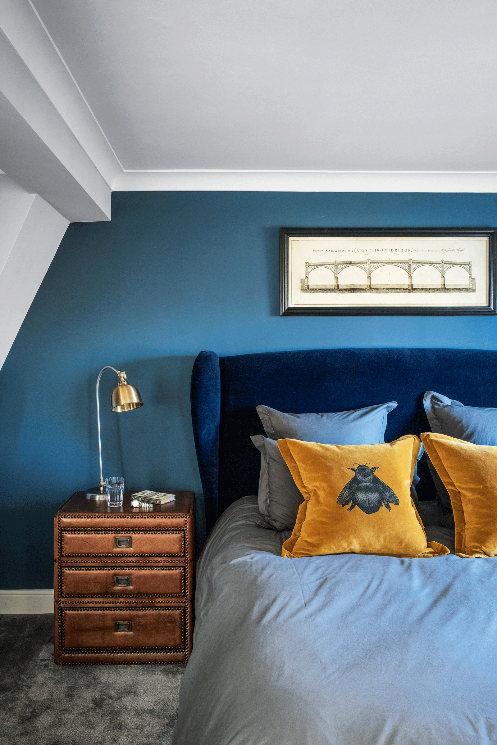 Blue bedroom with mustard yellow throw cushions